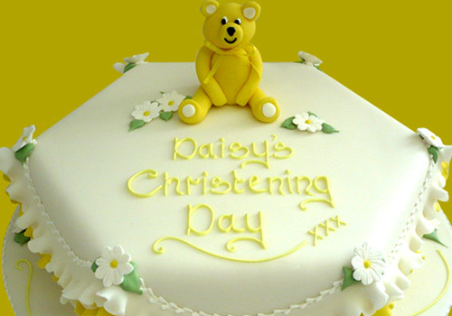 A yellow icing christening cake
